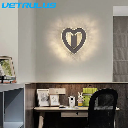 A modern gold decorbites crystal led wall lamp with a black frame and sparkling accents emitting a warm glow