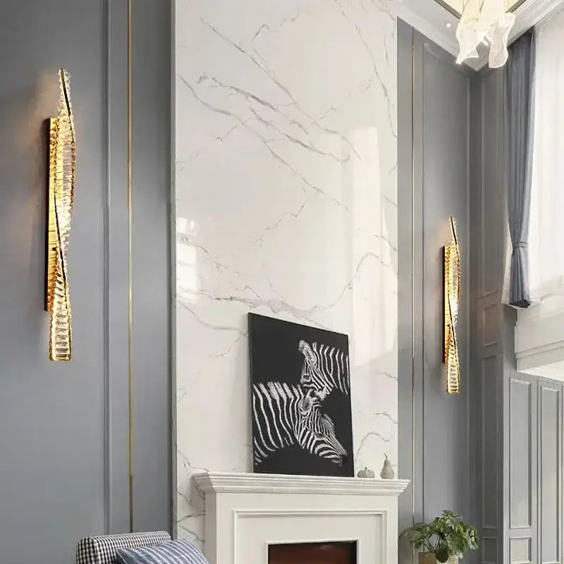Modern gold crystal led wall lamp with textured gold-toned design flanks white marble fireplace for luxury decorbites crystal led lighting