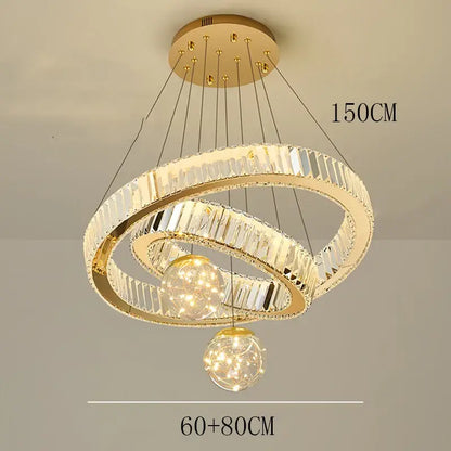 Modern gold pendant light with two interlocking crystal rings and brushed stainless finish for dining room use