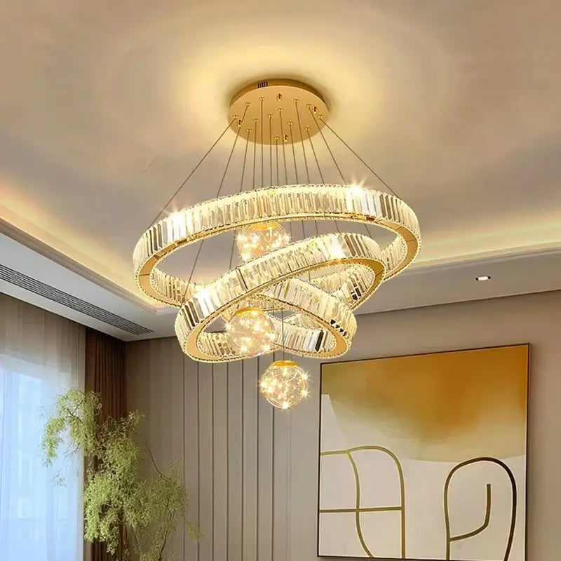 Modern gold crystal pendant light with interlocking rings and brushed stainless finish for dining room use