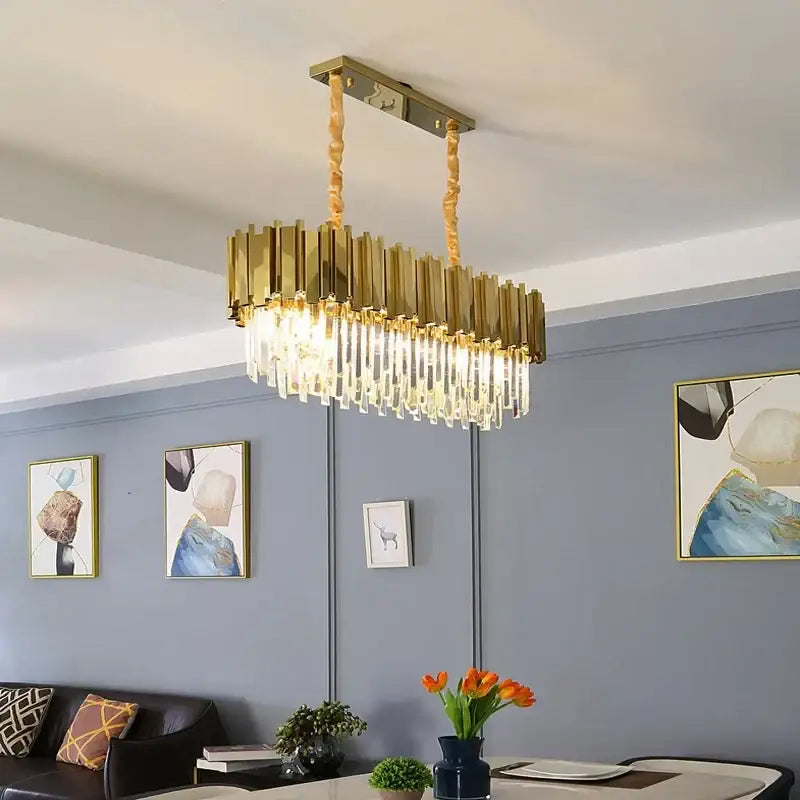 Modern gold crystal oval ceiling chandelier featuring gold-toned rectangular frame with brass bars and crystal prisms