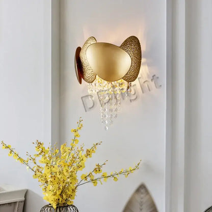 Modern gold-toned pendant light with textured egg-shaped metal arms and decorbites crystal tassles pendant beads
