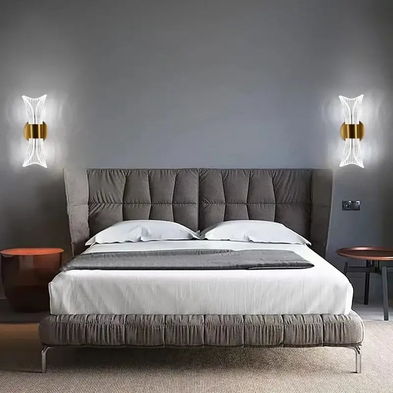 Modern gold crystal wall lamp with sculptural glass design above gray tufted velvet bed with white linens and dark gray throw blanket decorbites crystal wall lamp