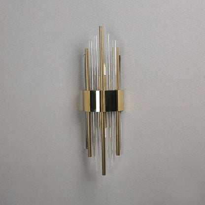 Modern gold crystal wall lamp featuring vertical clear and brass-colored glass rods for elegant bedroom decorbites crystal wall lamp