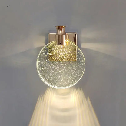 Modern gold crystal wall lamp featuring a gold-toned wall lamp with clear glass globe and sparkling flecks decorbites crystal wall