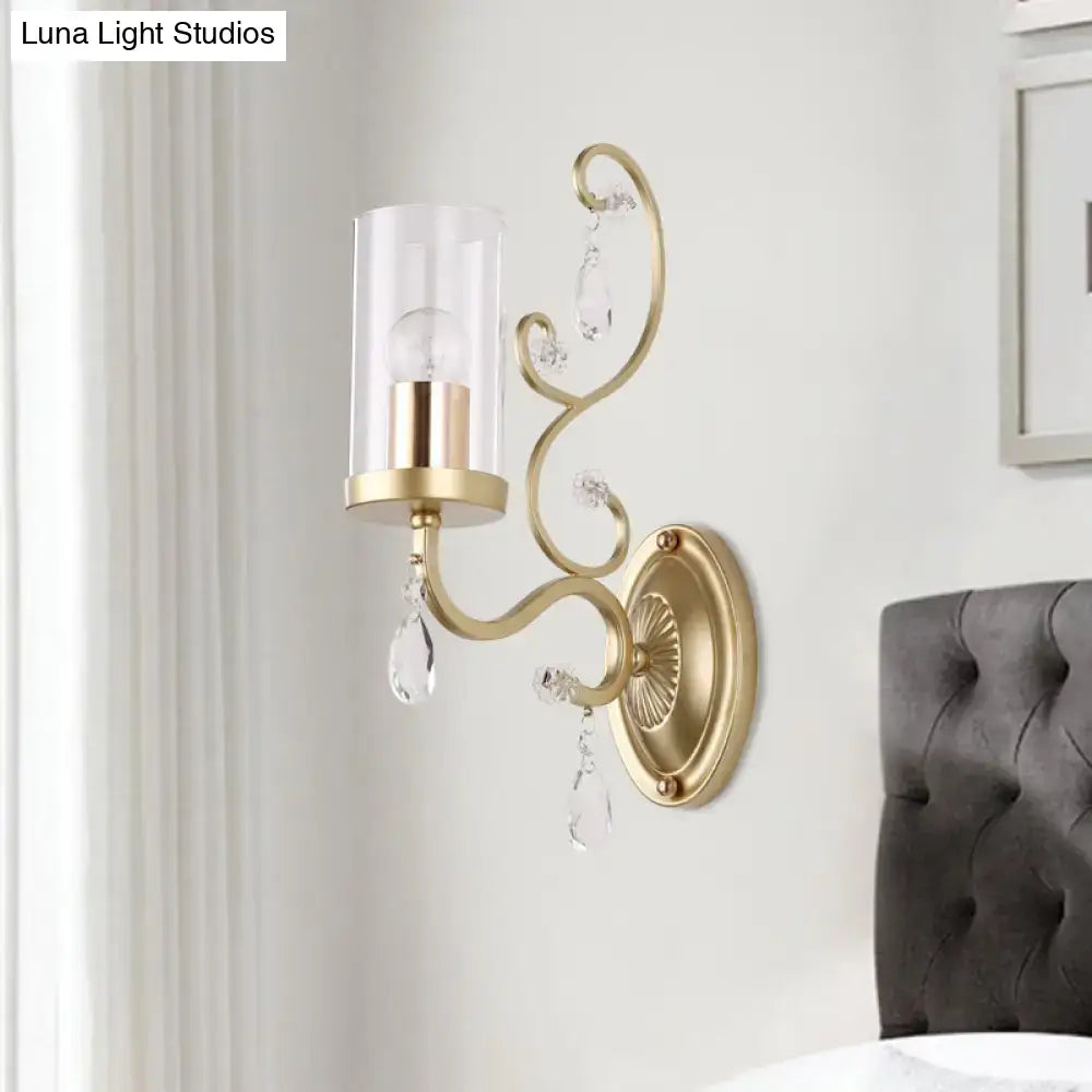 Modern gold wall light with clear crystal droplets and clear glass cylinder shade for bedroom lighting