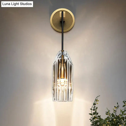 A modern gold crystal wall sconce with faceted clear glass and brass accents direct wired electric light fixture