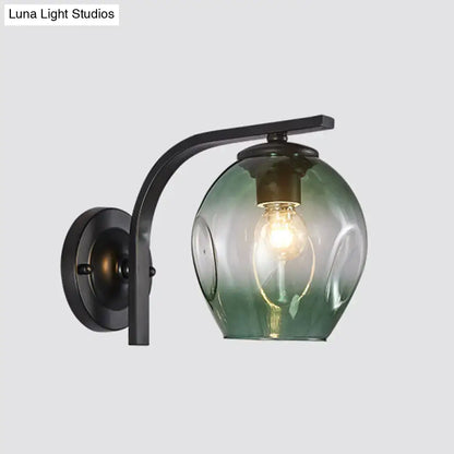 Modern gold curved arm glass wall sconce with sleek black metal and blue green oval glass globe for bedroom light