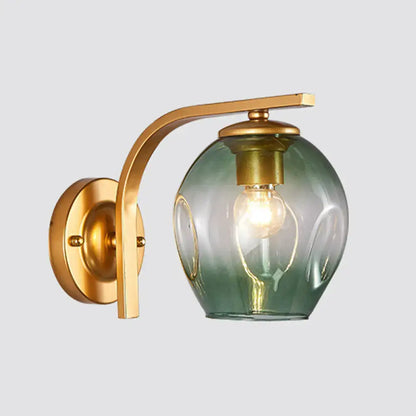 Modern gold curved arm glass wall sconce with brass finish and blue green gradient globe for bedroom lighting