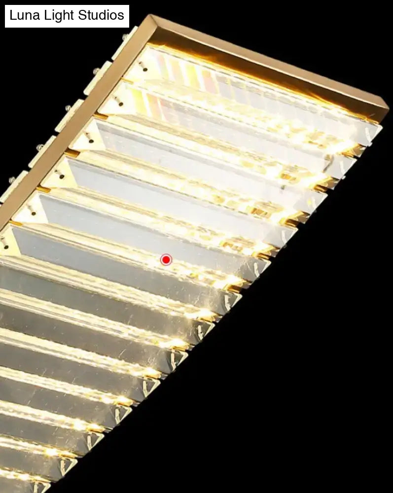 Modern gold curved crystal chandelier with rectangular gold frame, horizontal led strips, and clear faceted glass panels suspended crystal chandelier