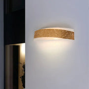 A modern gold curved wall lamp with textured finish and frosted glass diffuser for elegant wall mount lighting