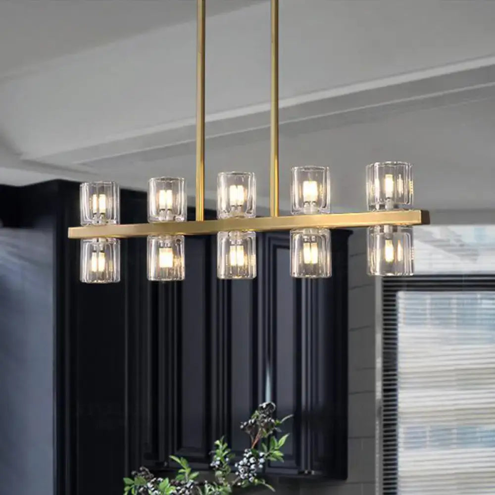 Modern gold cylinder island light fixture with clear glass candle-style shades for dining room chandelier use