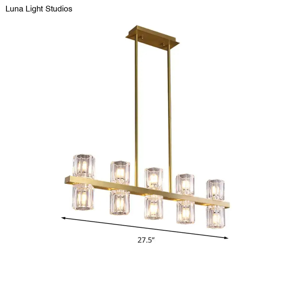 Modern gold cylinder island light chandelier with six clear faceted glass candle bulbs on a horizontal bar