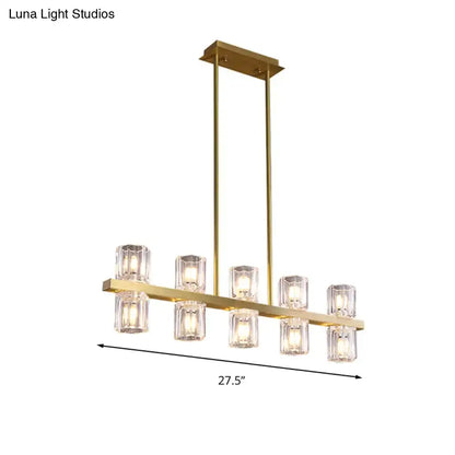 Modern gold cylinder island light chandelier with six clear faceted glass candle bulbs on a horizontal bar