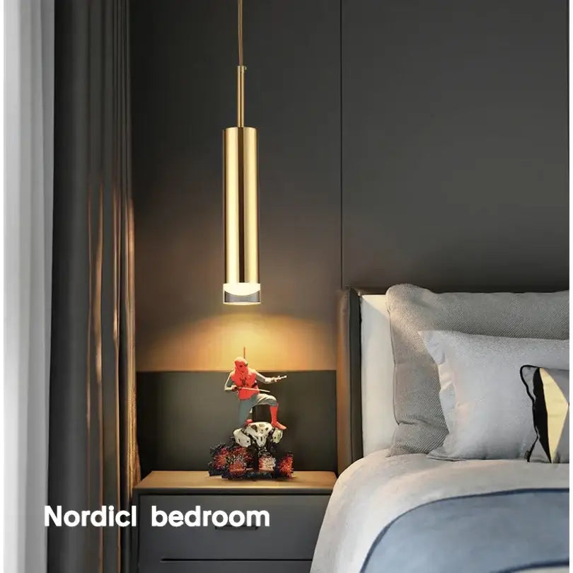 Modern gold cylindrical led pendant light with sleek design hanging above bedside table for decorbites gold modern decor
