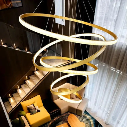 Modern gold decorbites crystal chandelier with multiple glowing rings suspended by thin cords for staircase lighting