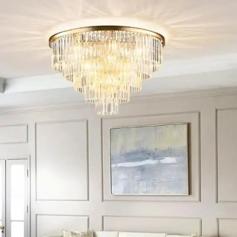 A tiered crystal flush ceiling light with gold-toned metal frame and cascading clear glass prisms by decorbites