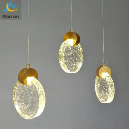 Three modern gold decorbites crystal led bedroom pendant lights with translucent bubble-filled glass shades emitting warm glow