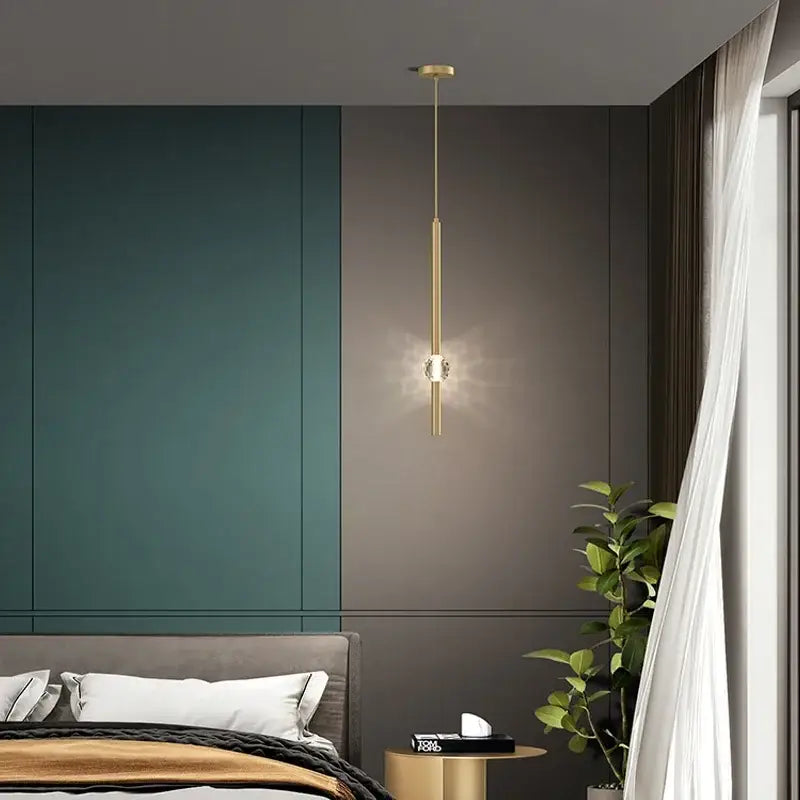 A modern gold decorbites crystal led pendant light with a cylindrical body and central crystal accent for bedrooms