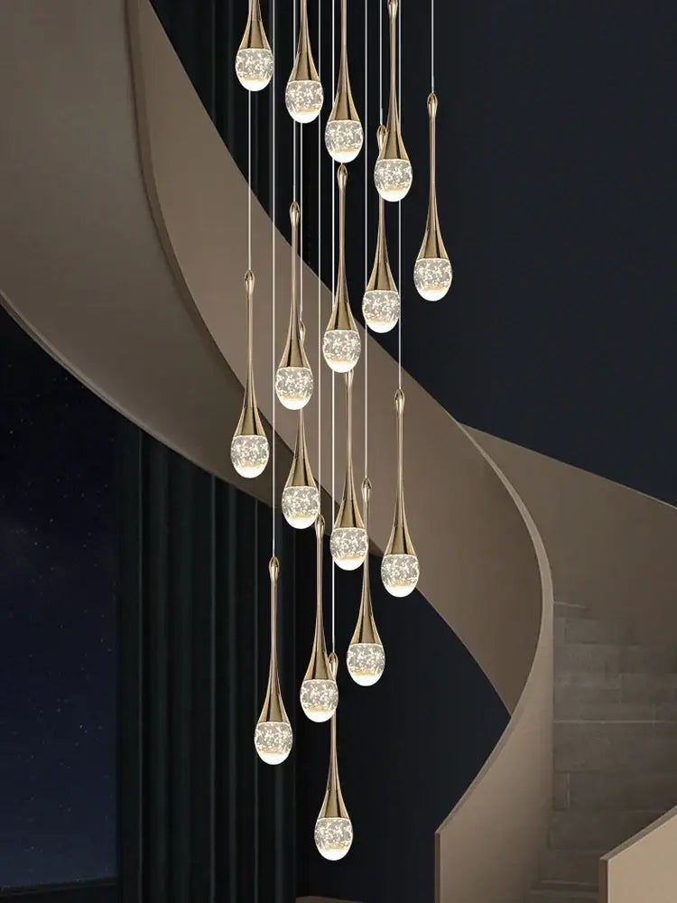 A modern gold decorbites crystal led chandelier with teardrop pendants and clear globes for staircase lighting