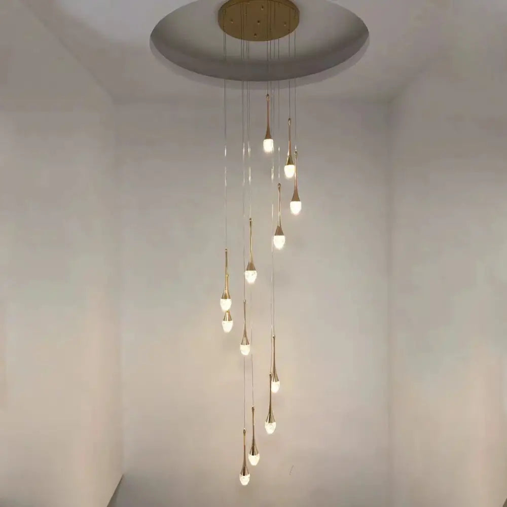 A modern gold-toned decorbites crystal led chandelier with teardrop lights suspended from a circular mount