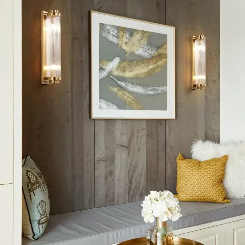 Modern gold decorbites crystal wall sconce featuring gold-framed abstract feathers in white silver and gold on gray background