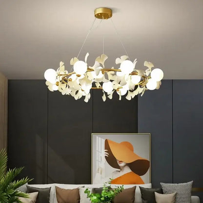 A modern gold decorbites gingko leaf branch chandelier with a circular frame and white petal-shaped shades for living room lighting