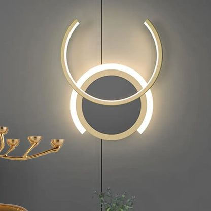 Modern gold dual ring led wall sconce with two concentric circular rings glowing warmly for bedroom lighting