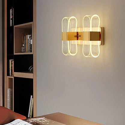 Modern gold accent elliptical led wall lamp with illuminated curved wireframe design for bedroom decorbites decor