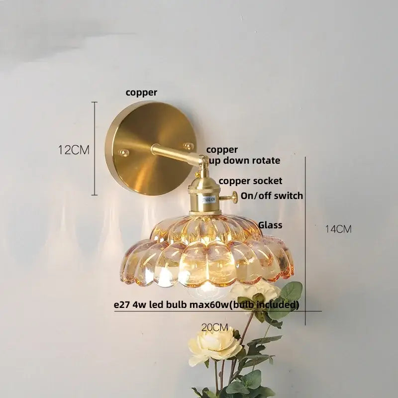 A vintage-style wall lamp with a brass copper finish and amber scalloped clear glass wall light shade for bedroom use