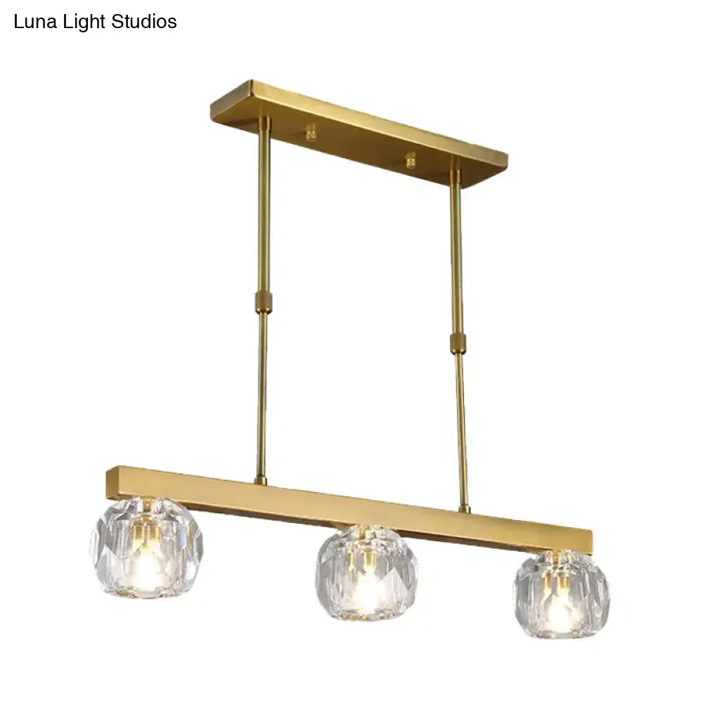 Modern gold island pendant light featuring three faceted crystal sphere shades for kitchen and dining room use