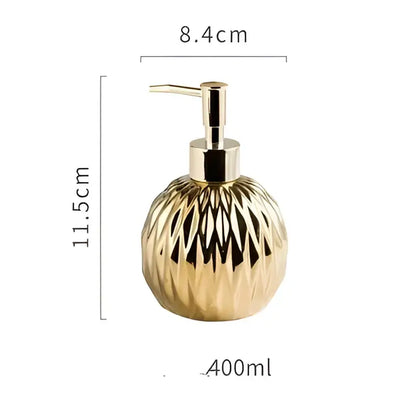 Modern gold faceted glass liquid soap dispenser with a sleek metallic pump for bathroom decor use