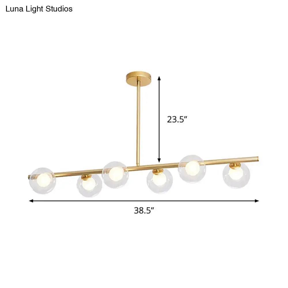 Modern gold finish linear pendant light with five clear glass globes and sleek horizontal bar design for kitchen use