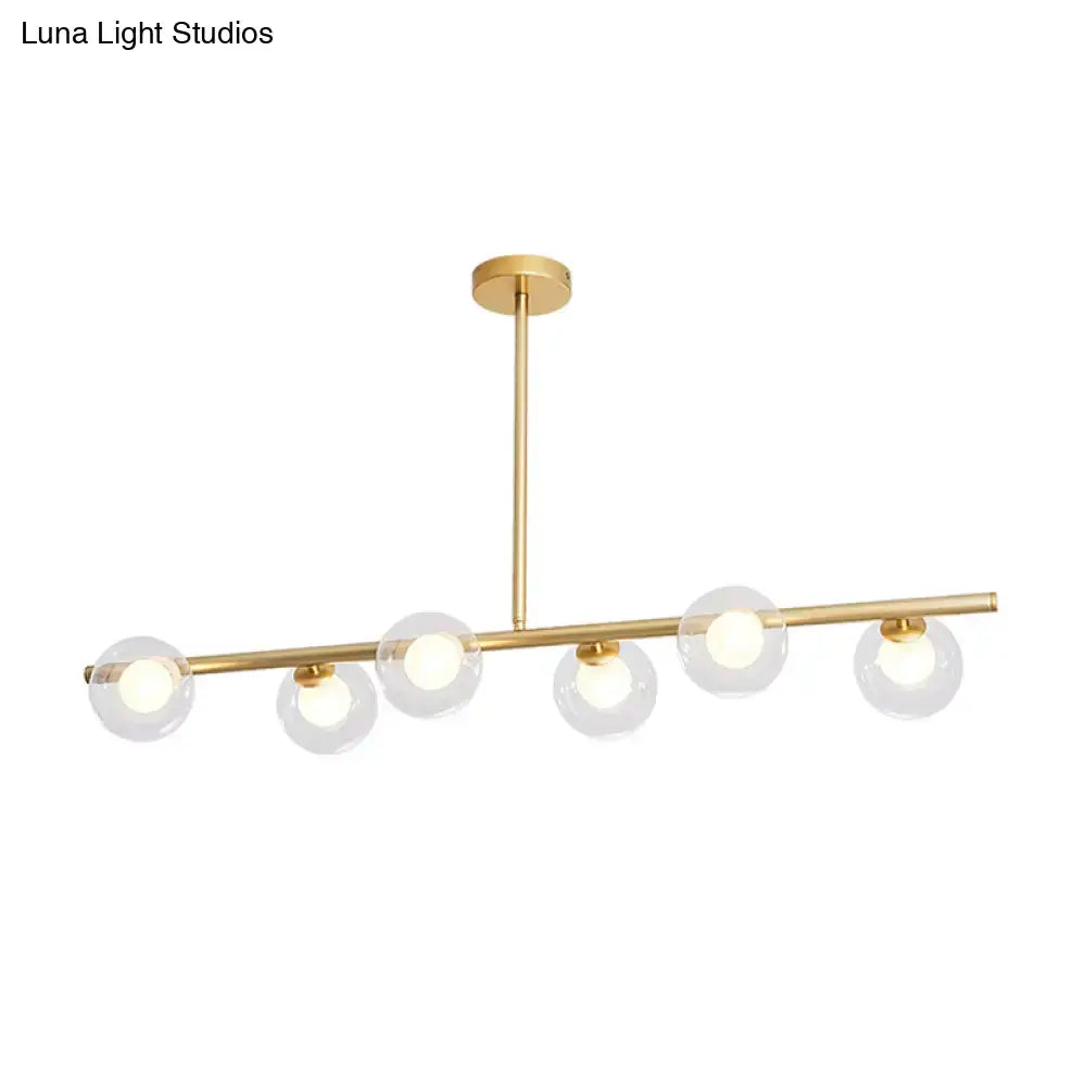 Modern gold finish linear pendant light with five clear glass globes and sleek horizontal bar design for kitchen use