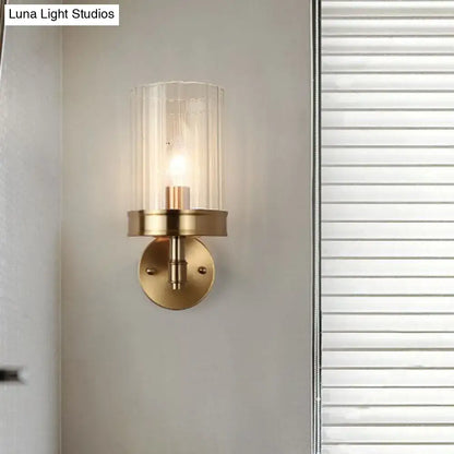 Modern gold finish wall light with brass finish and clear textured glass shade suitable for bedroom sconce with warm color temperature