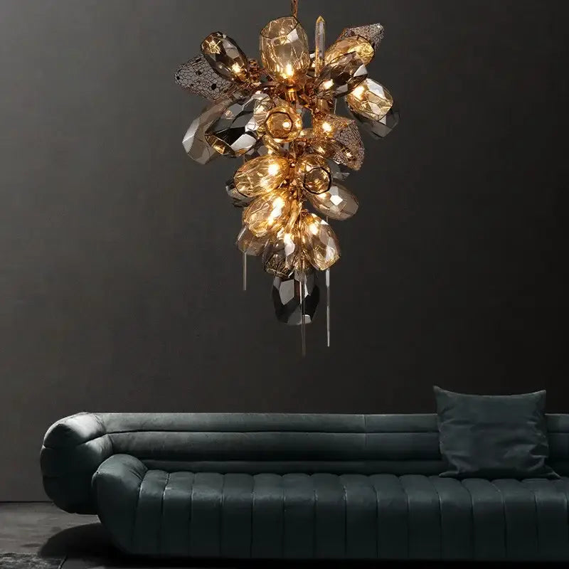 Modern gold flower glass shades led chandelier with faceted amber glass shades suspended above dark green sofa