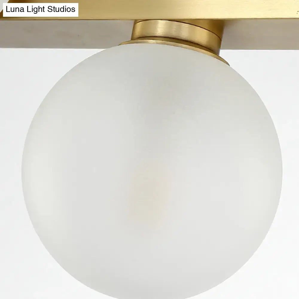 Modern gold frosted glass globe pendant light with brass base and adjustable chain cord length for dining room island