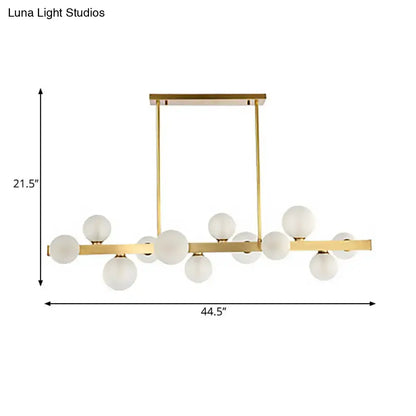 Modern gold frosted glass pendant light with chain cord length and globe bulbs arranged in a linear pattern for dining room island