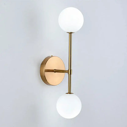 Modern gold led wall sconce with frosted glass globe shades ideal for bedroom lighting