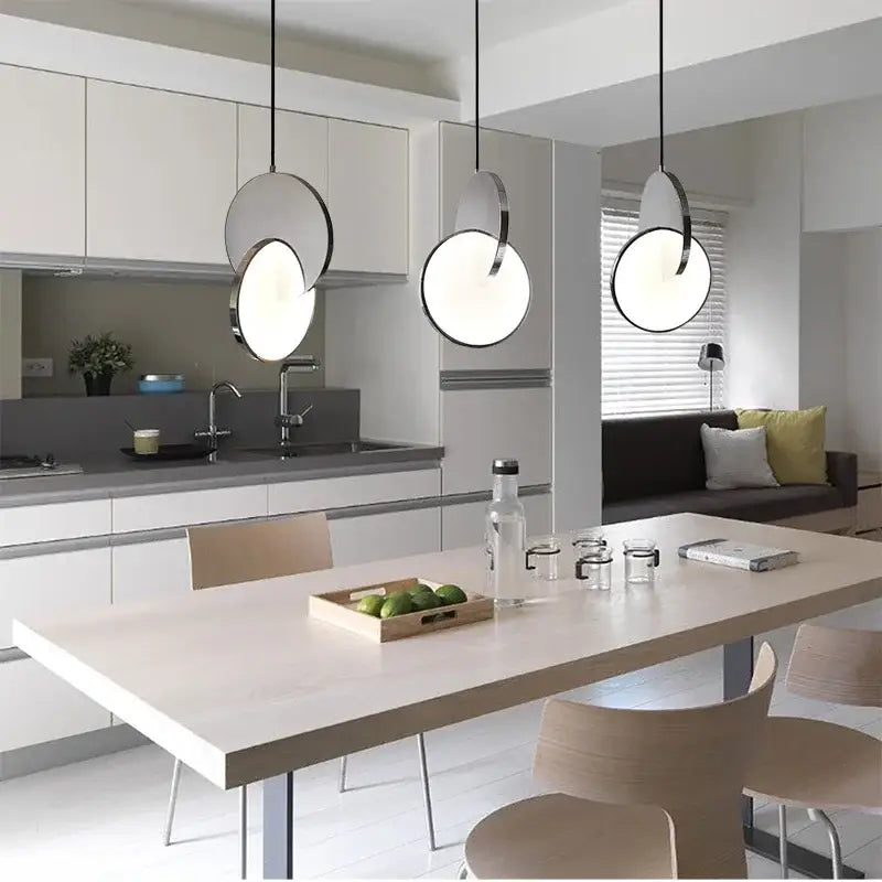 Three modern pendant lights with geometric circle frosted glass shades and black metal frames for dining room decorbites geometric circle