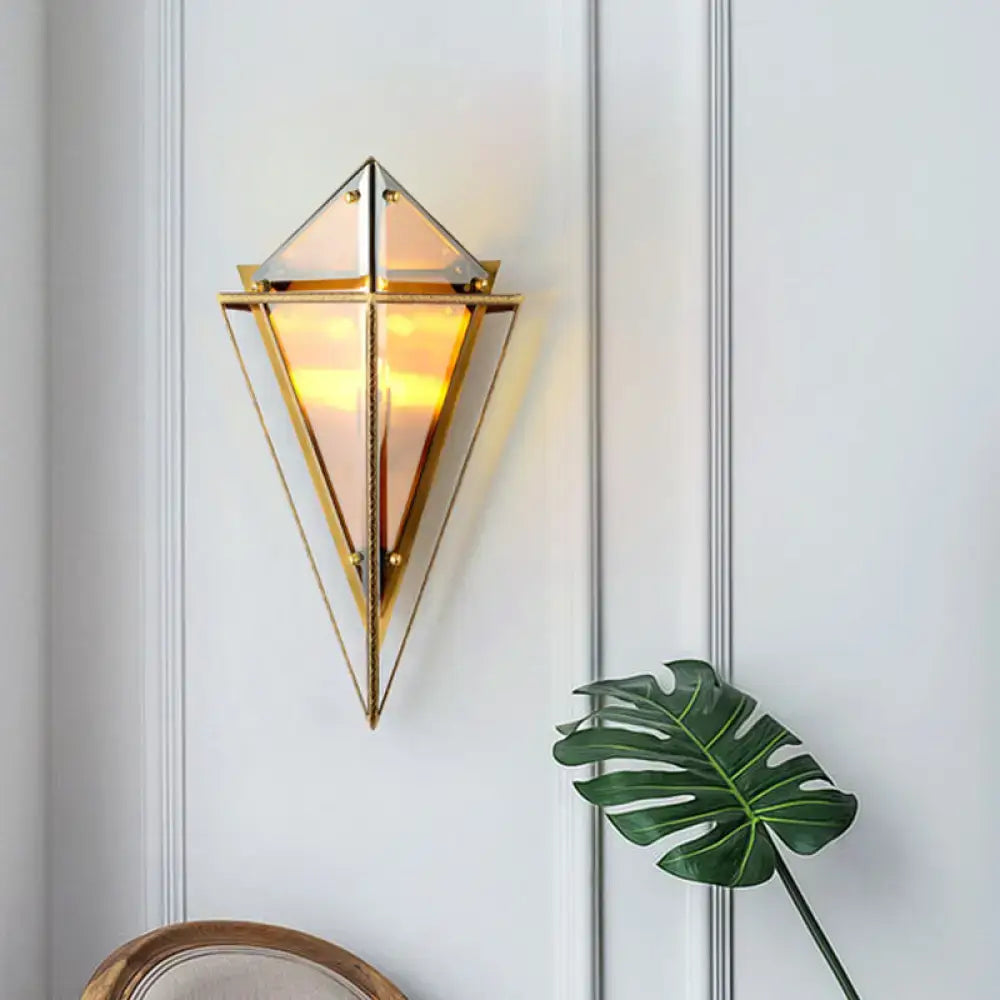 Modern gold geometric wall sconce with amber triangular glass panels and warm glowing light for living room use