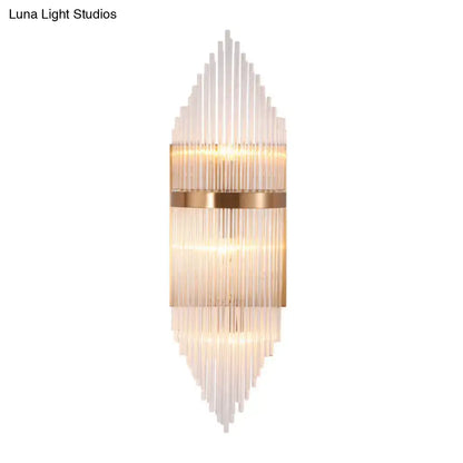 Modern gold geometric wall sconce with clear glass rods in a cascading pattern and warm brass accents for living room fixture height
