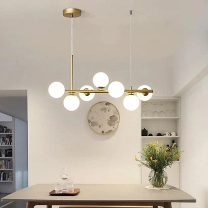 Modern gold pendant light with six frosted glass ball bulbs in linear design perfect for dining room decorbites glass ball