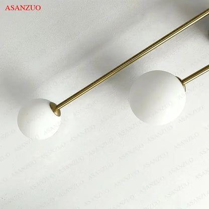 Modern gold glass ball wall lamp with dual frosted matte white glass ball shades on slender gold rods by decorbites