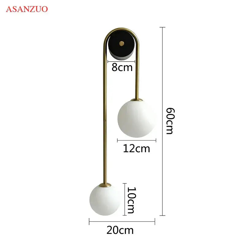 Modern wall lamp by Asanzuo with brass curved arm and dual matte white glass ball gold shades for bedroom decorbites glass ball