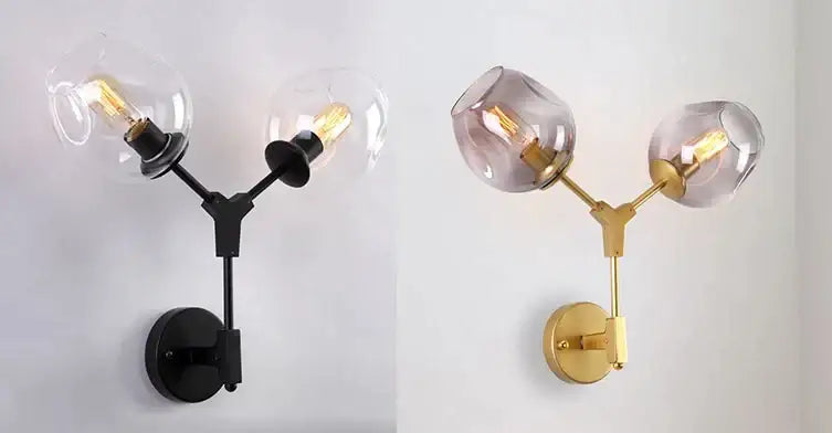 Modern gold two-light wall sconce with clear and smoked glass pendant lights on metal arms for dining room use