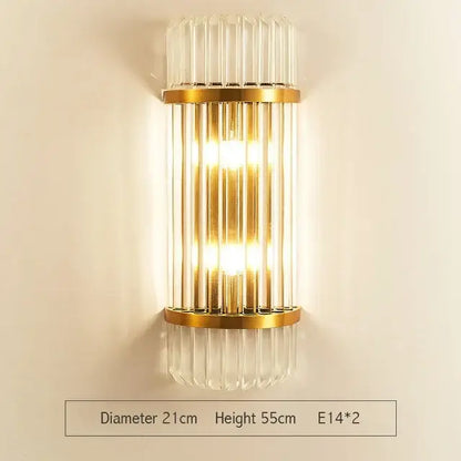 Modern gold wall sconce with vertical glass rod crystal design and warm glowing light for bedroom use