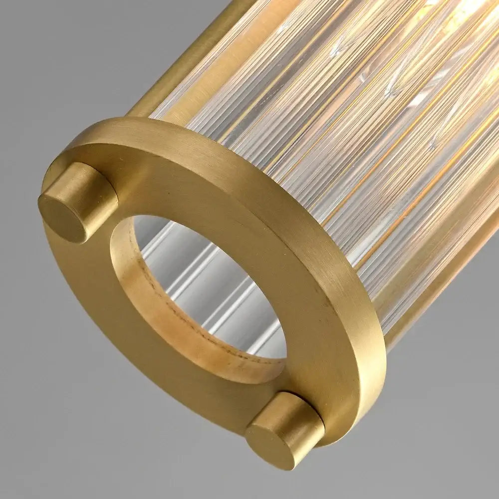Modern gold glass shade pendant lights with gold-toned cylindrical rods and brushed brass fixture for kitchen island