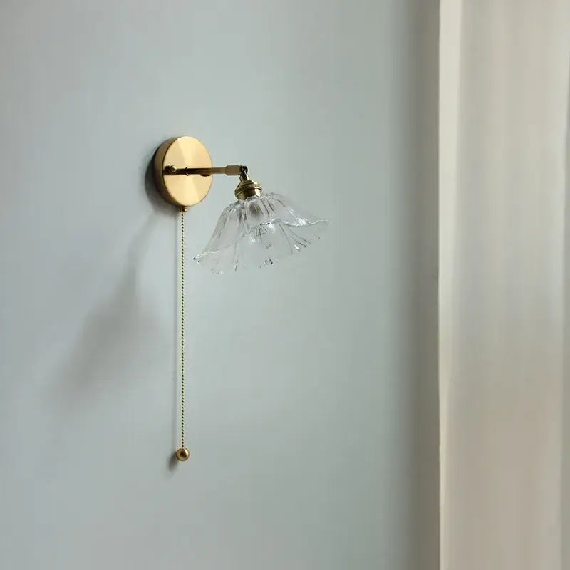 Modern gold brass wall light with clear petal-shaped glass shade and elegant pull chain for bedroom led wall use
