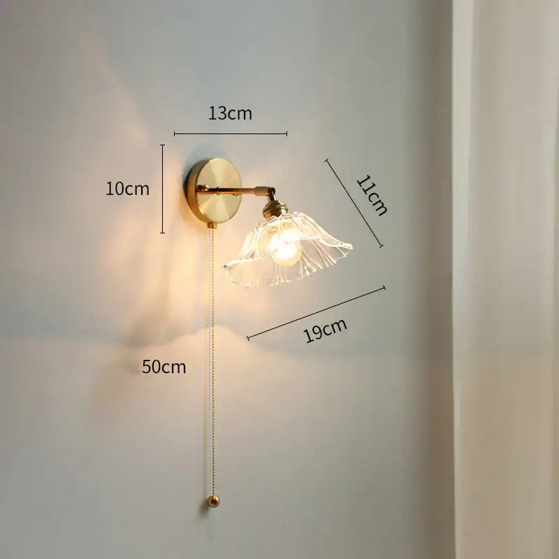 Modern gold wall light with LED glass shade and elegant pull chain for bedroom lighting
